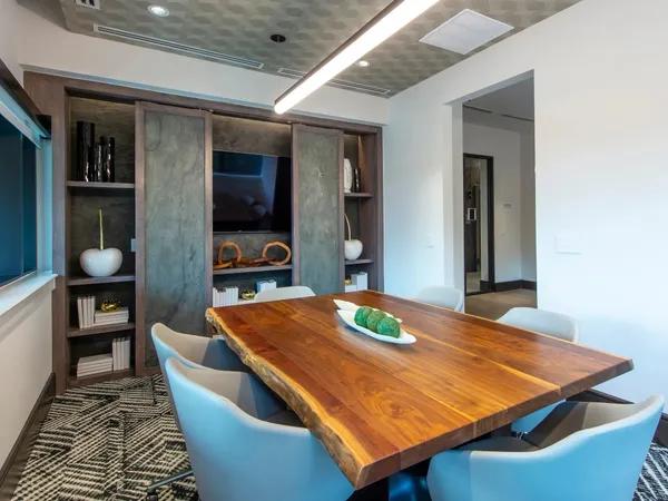 a living room with furniture kitchen view and a chandelier