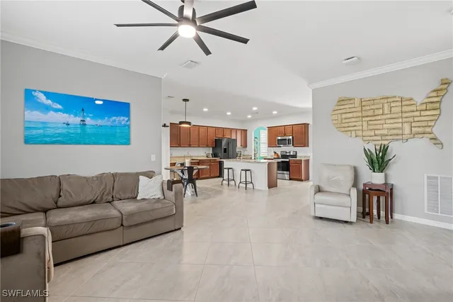 a living room with furniture kitchen view and a chandelier