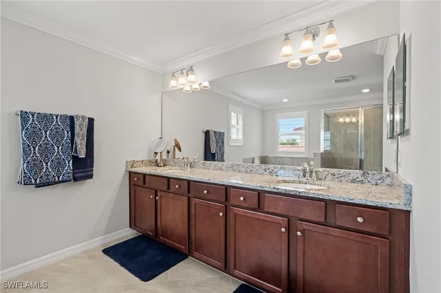 a bathroom with a granite countertop double vanity sink and a mirror