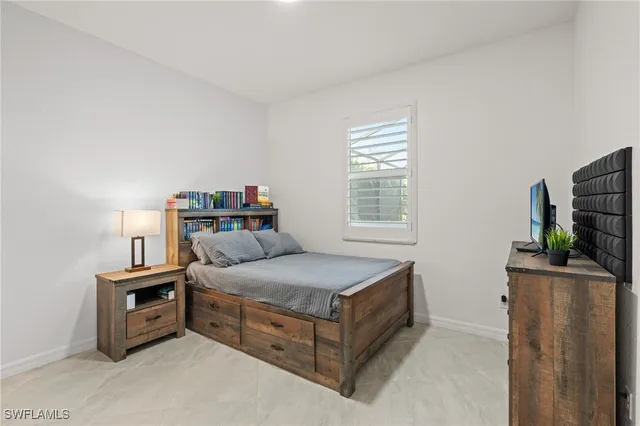 a bedroom with a bed and a flat tv screen on a dresser