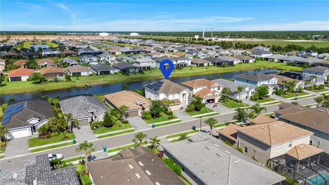 an aerial view of a city with lots of residential buildings ocean and mountain view in back