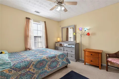 a living room with furniture a ceiling fan and a window