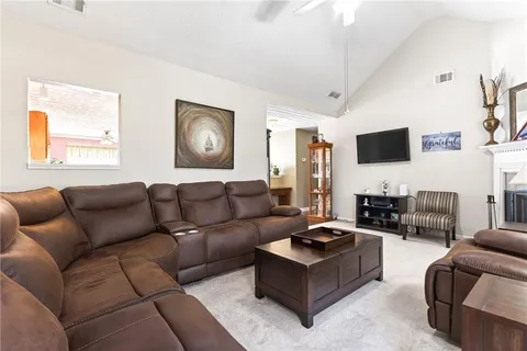a living room with furniture a flat screen tv and a table