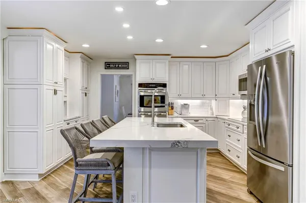 a kitchen with refrigerator cabinets and wooden floor