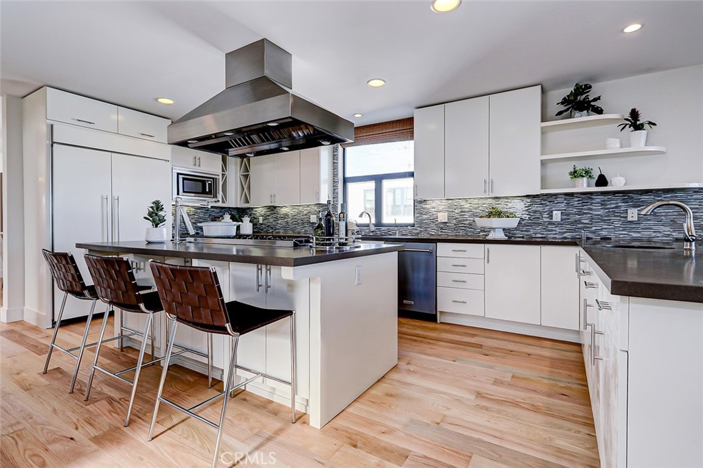 425 26th Street Manhattan Beach, CA 90266 - Photo 28 of 55 a kitchen with stainless steel appliances kitchen island granite countertop a table chairs sink and cabinets