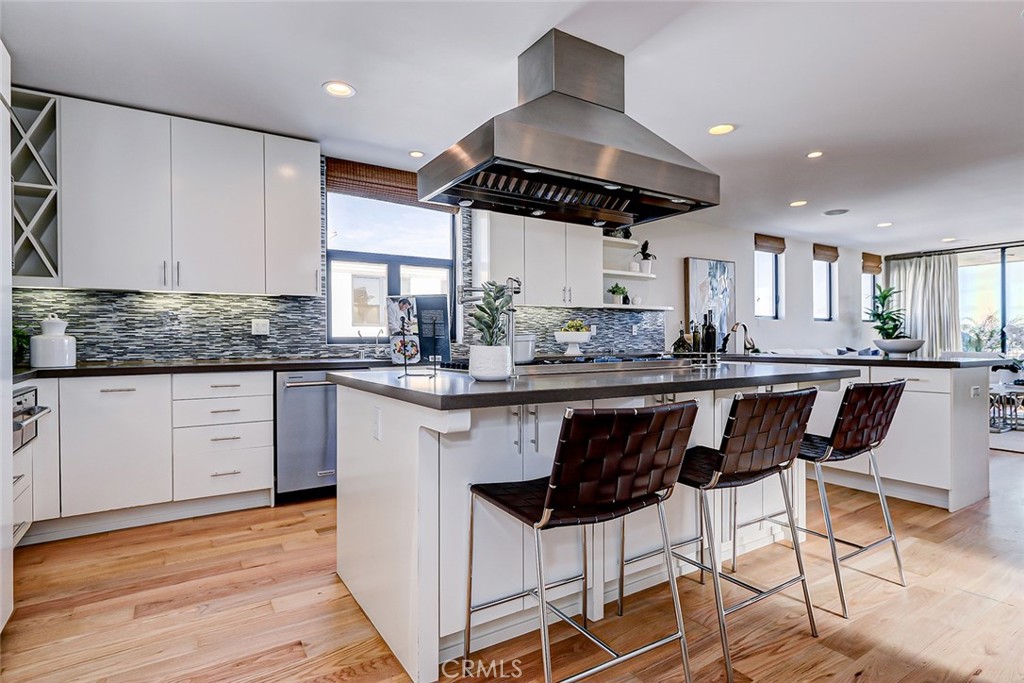 425 26th Street Manhattan Beach, CA 90266 - Photo 29 of 55 a kitchen with stainless steel appliances kitchen island granite countertop a table chairs in it and wooden floors