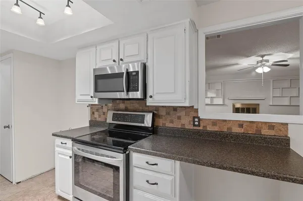 a kitchen with stainless steel appliances granite countertop a stove a sink and a microwave