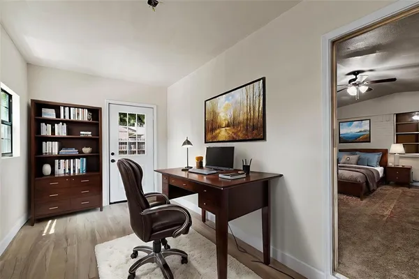 a view of a workspace with furniture and a bookshelf