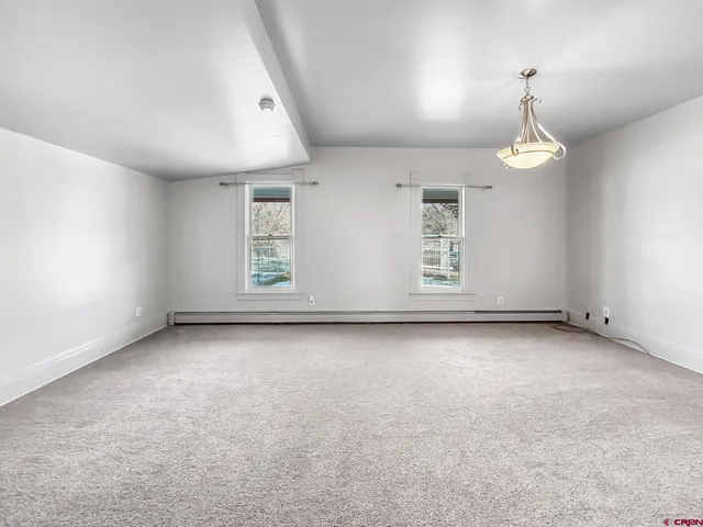 an empty room with windows and chandelier