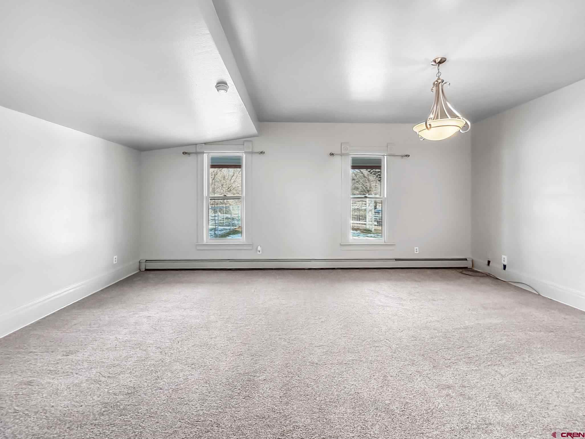 17343 Surface Creek Road Cedaredge, CO 81413 - Photo 11 of 45 an empty room with windows and chandelier