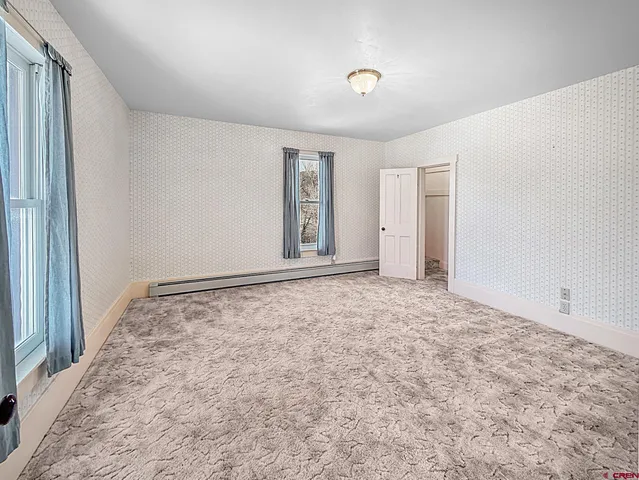 a view of a room with wooden floor windows and wooden floor