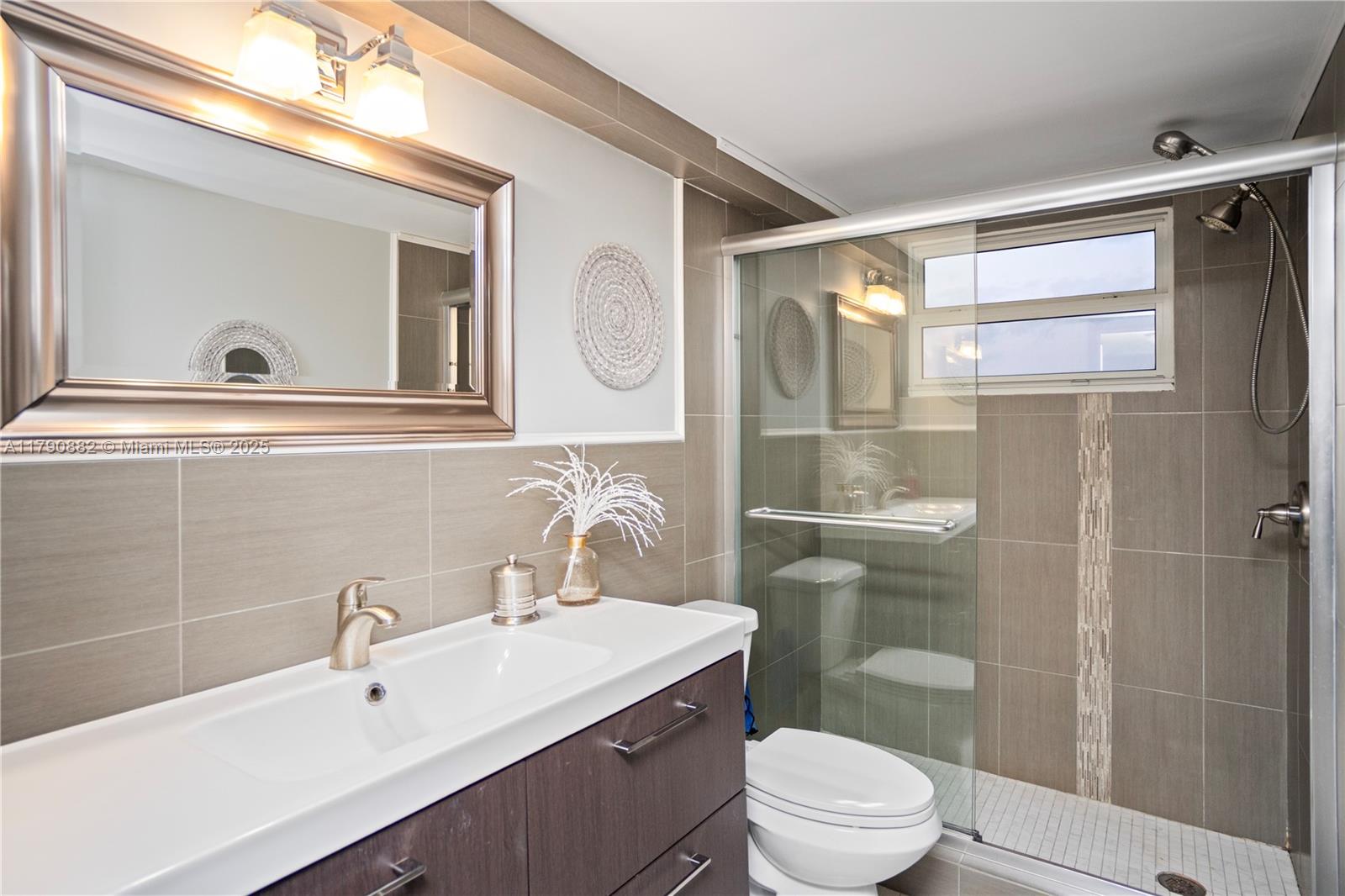 901 South Surf Road, Unit 603 Hollywood, FL 33019 - Photo 17 of 26 a bathroom with a sink a toilet a mirror and shower