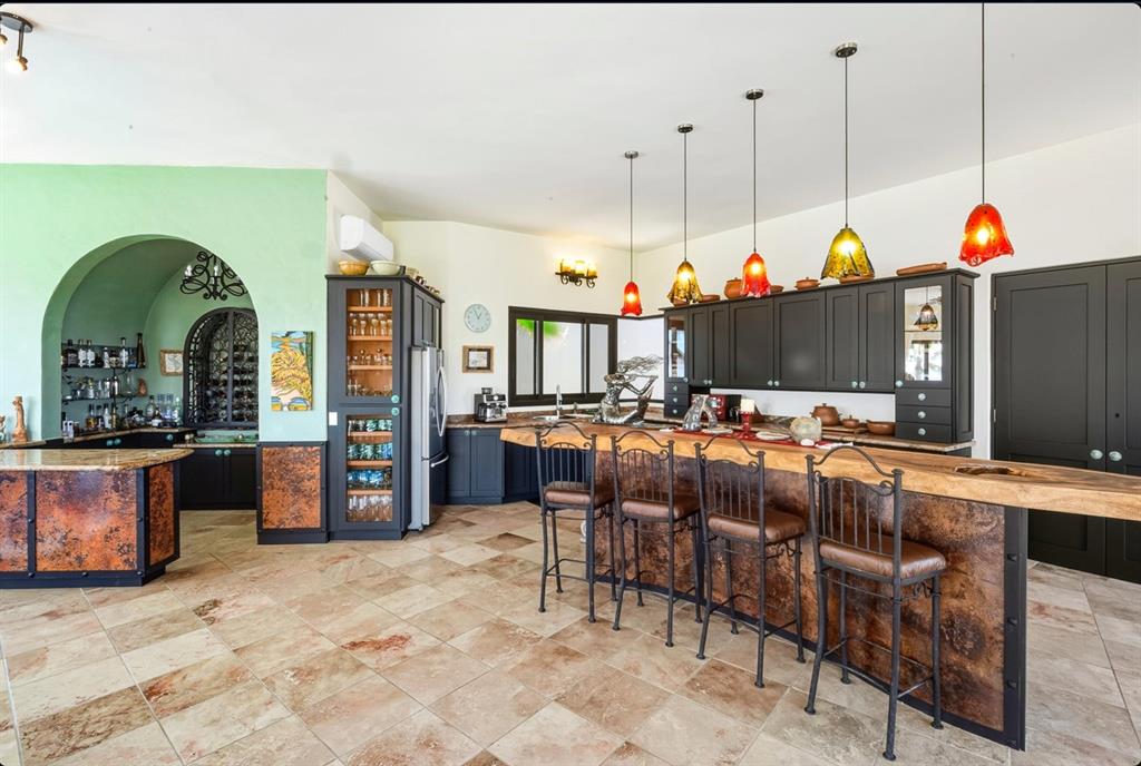 1 Arriba De Lane Roca, OUTSIDE OF THE US 99999 - Photo 7 of 40 Kitchen with a kitchen breakfast bar, glass insert cabinets, and hanging light fixtures