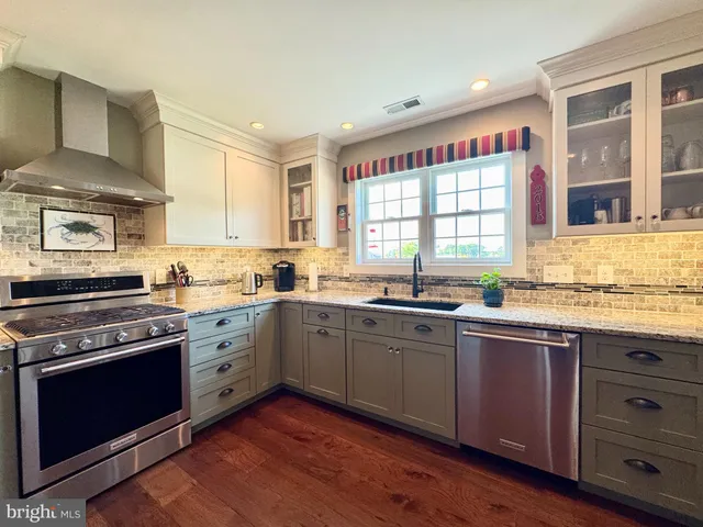a kitchen with stainless steel appliances granite countertop a stove and a sink