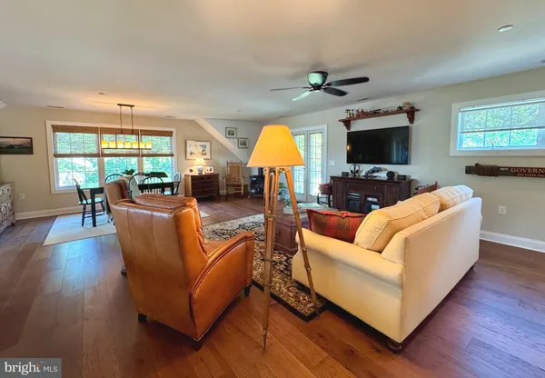a living room with furniture flat screen tv and wooden floor