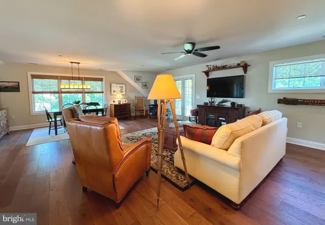 a living room with furniture flat screen tv and wooden floor
