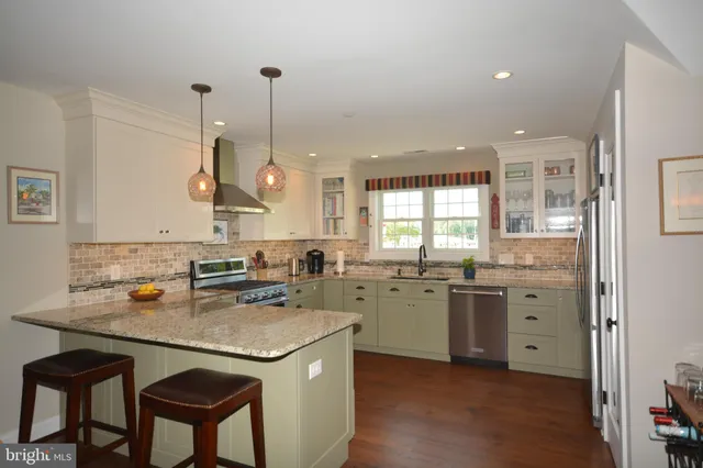 a kitchen with a sink a stove a dining table and chairs