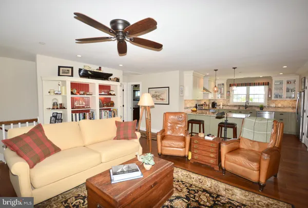 a living room with furniture kitchen view and a chandelier