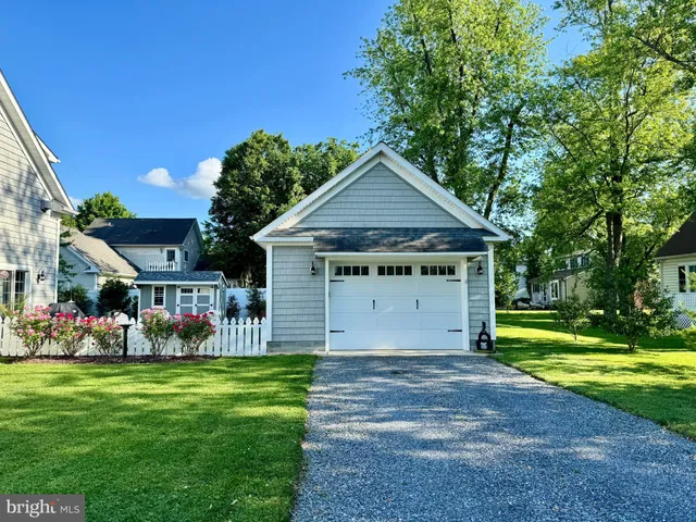 a view of a house with a big yard and large trees