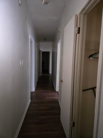 a view of a hallway with wooden floor and staircase