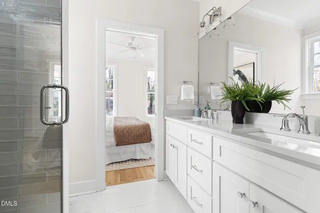 a bathroom with a granite countertop sink a mirror and a shower