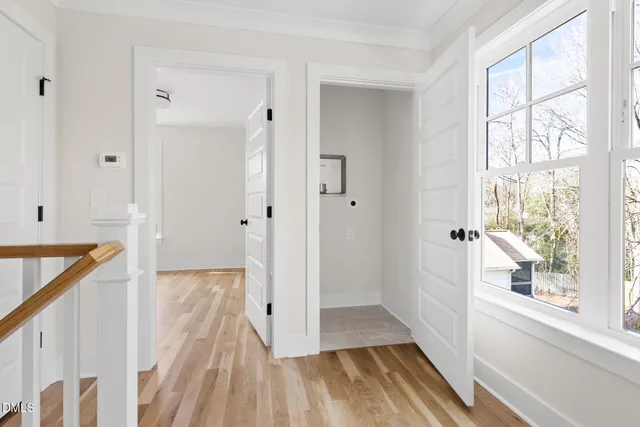 a view of a hallway with wooden floor and staircase
