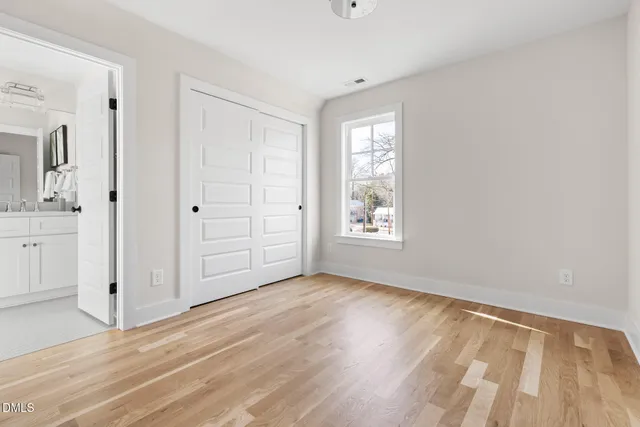 an empty room with windows and closet