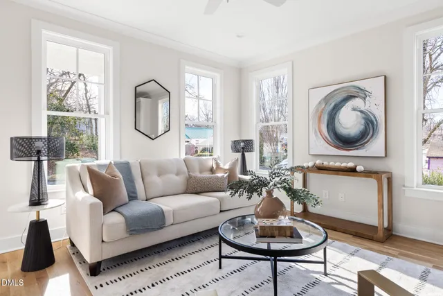 a living room with furniture a window and a potted plant