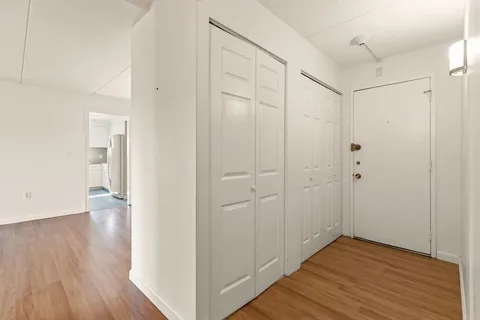 a view of an empty room with wooden floor