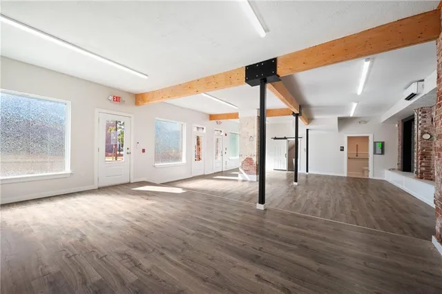a view of a livingroom with wooden floor and furniture