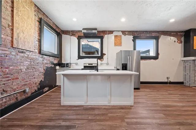a view of a kitchen with a refrigerator cabinets and wooden floor