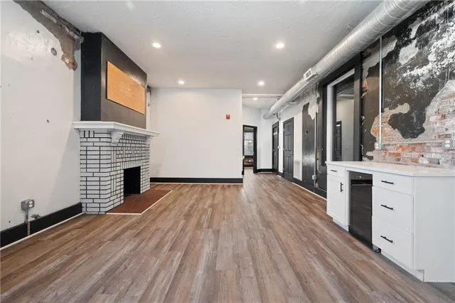 an empty room with wooden floor and a bathroom
