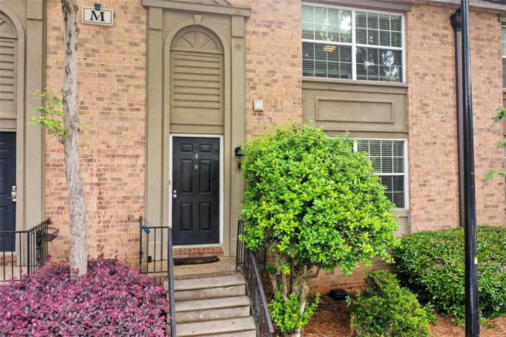 front view of a house with a potted plant and windows