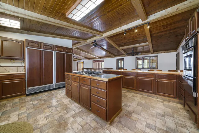 a large kitchen with stainless steel appliances wooden cabinets and a counter top