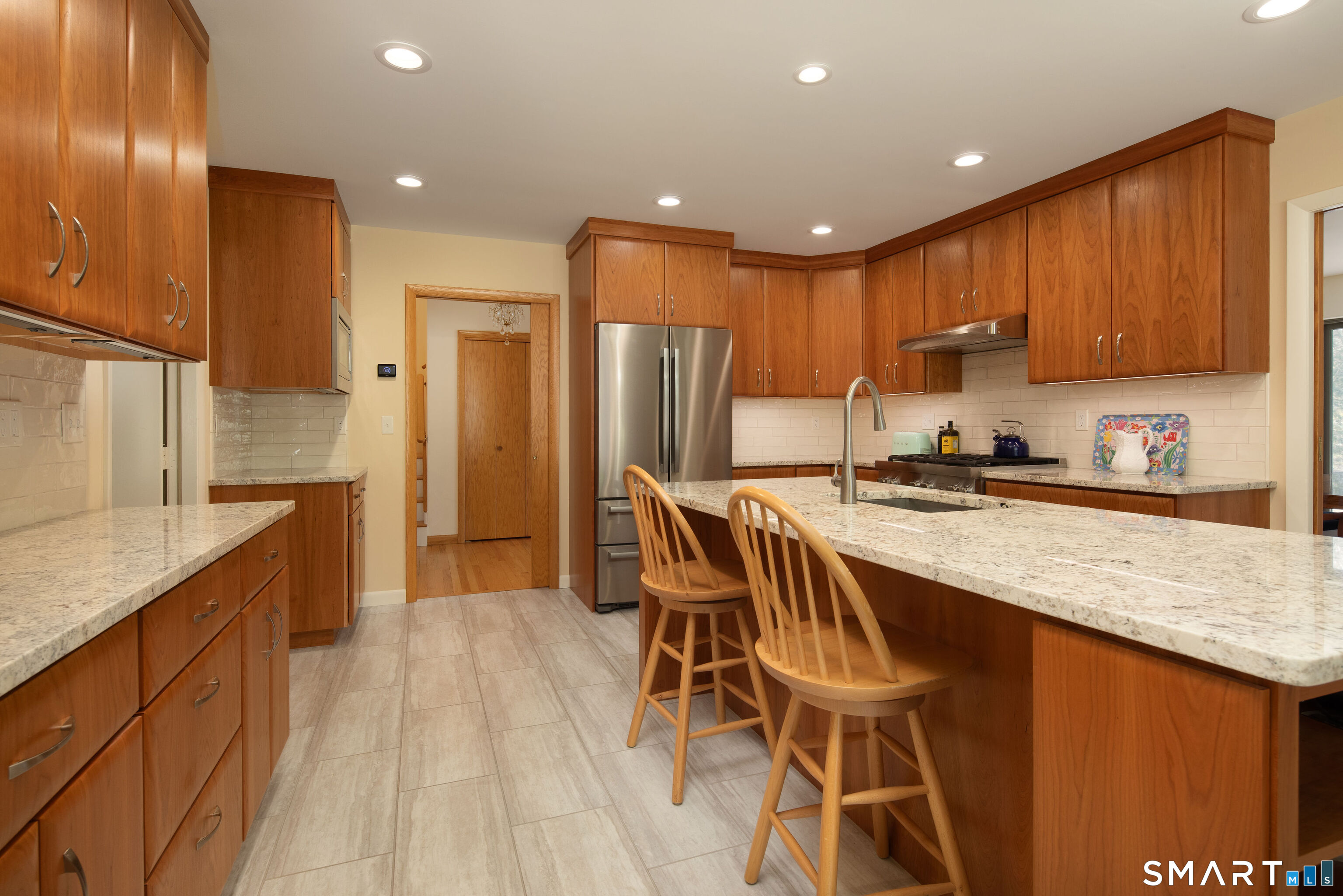 150 Sunset Ridge Road Norfolk, CT 06058 - Photo 12 of 34 center island with sink, breakfast bar, quartz counters, gas range, recessed lighting, opens to 3 season Porch