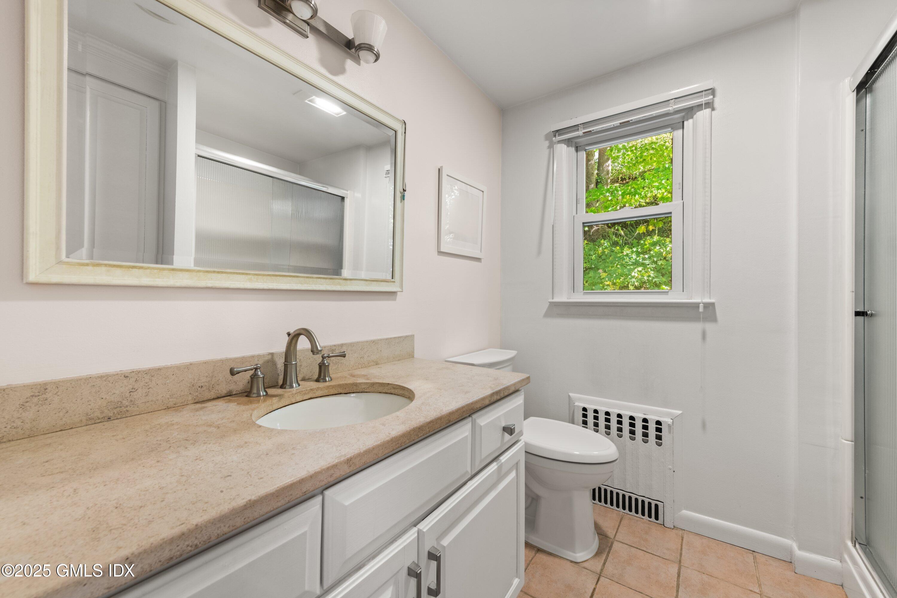 3 Green Lane Greenwich, CT 06831 - Photo 19 of 24 a bathroom with a granite countertop sink a toilet and a mirror