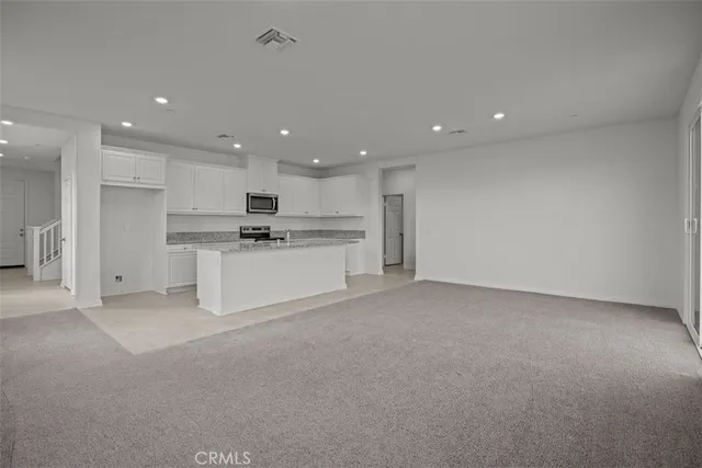 a open kitchen with white cabinets and stainless steel appliances