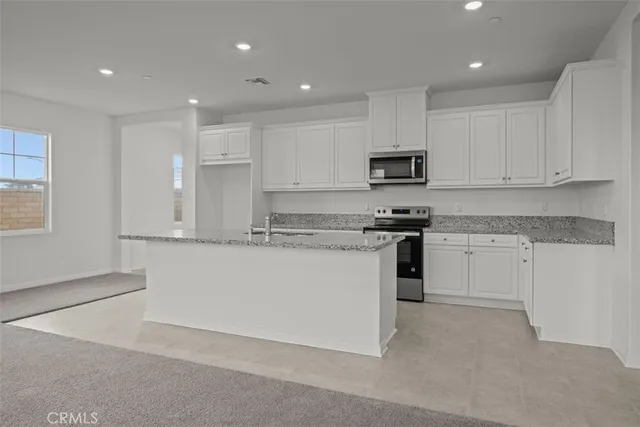 a kitchen with granite countertop white cabinets and a sink
