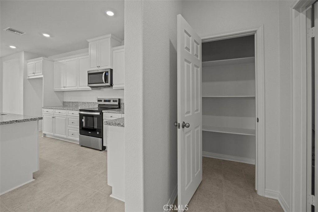 25632 Ranch House Road Homeland, CA 92548 - Photo 20 of 26 a kitchen with cabinets and stainless steel appliances