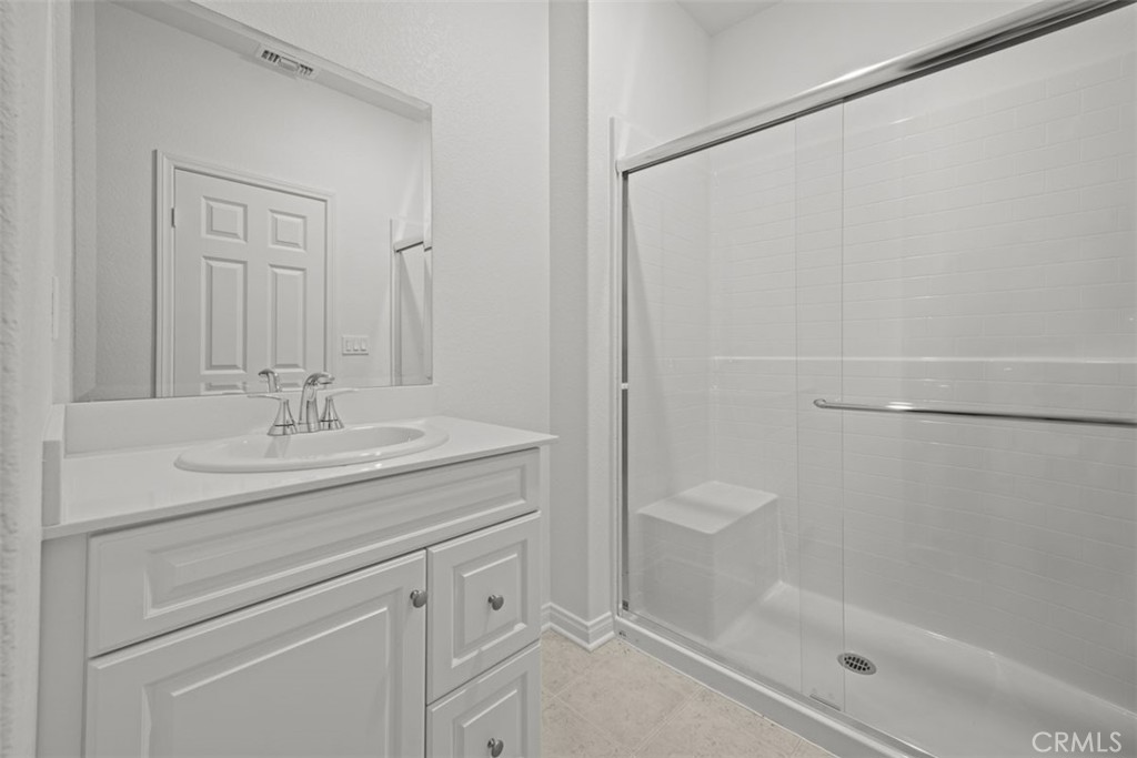 25632 Ranch House Road Homeland, CA 92548 - Photo 21 of 26 a bathroom with a shower sink vanity and mirror