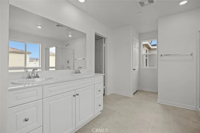 a spacious bathroom with a granite countertop sink a mirror and shower