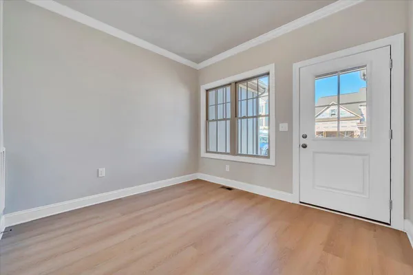 an empty room with wooden floor and windows