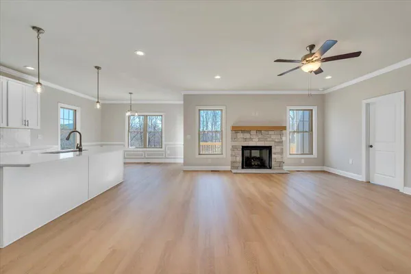 a view of an empty room with a fireplace and a window