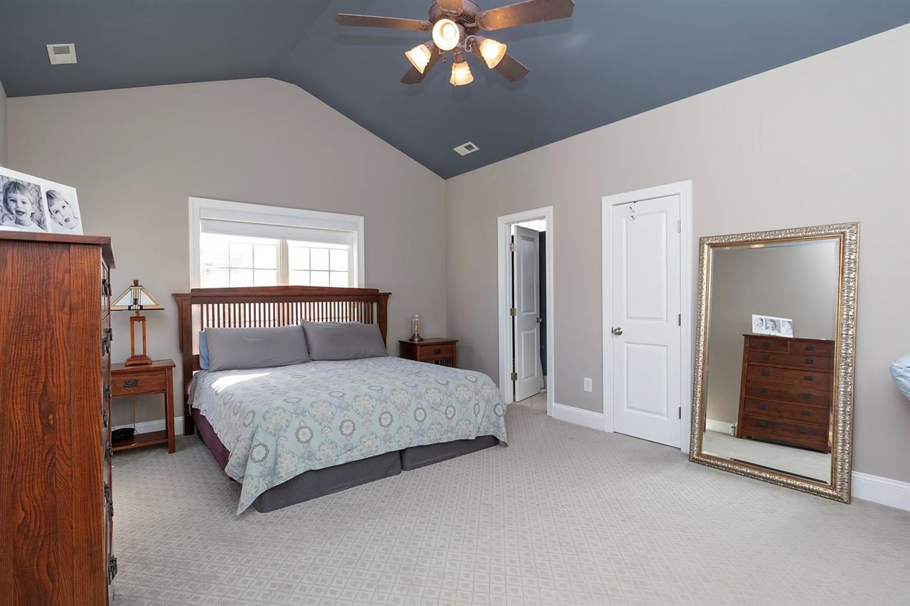 1112 Harp Street Raleigh, NC 27604 - Photo 12 of 25 a bedroom with a large bed and a chandelier