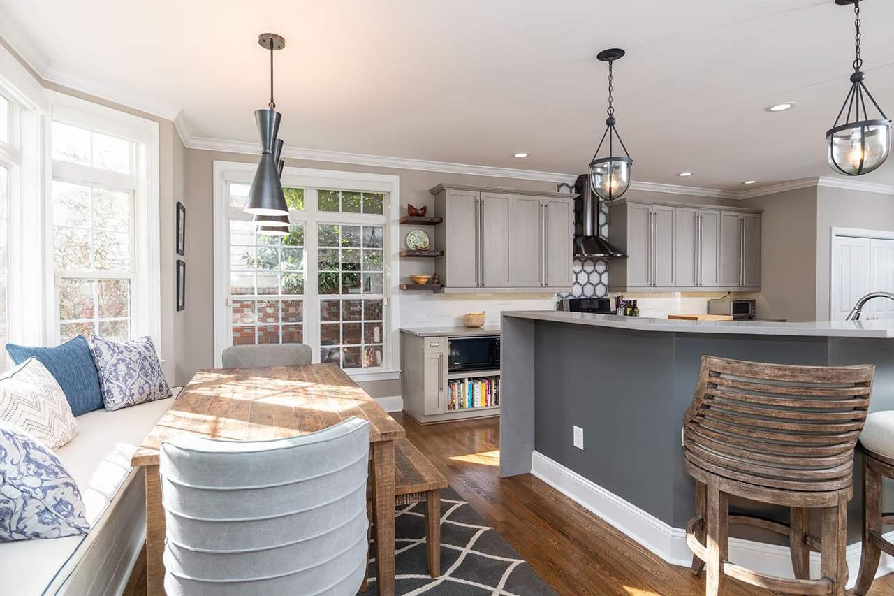 1112 Harp Street Raleigh, NC 27604 - Photo 5 of 25 a kitchen with stainless steel appliances kitchen island granite countertop a table chairs in it and wooden floors