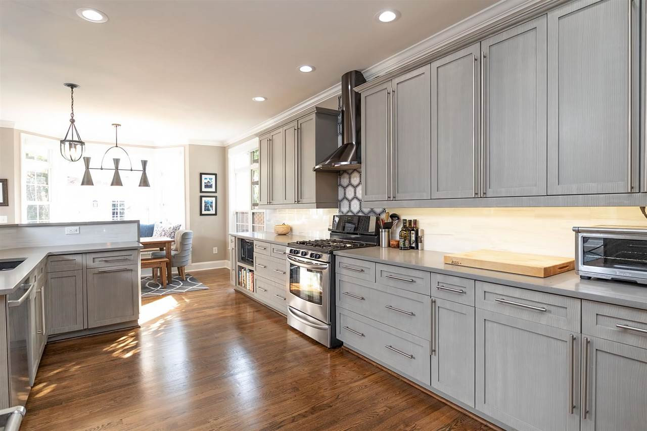 1112 Harp Street Raleigh, NC 27604 - Photo 8 of 25 a kitchen with stainless steel appliances granite countertop a stove top oven a sink a dining table and chairs with wooden floor