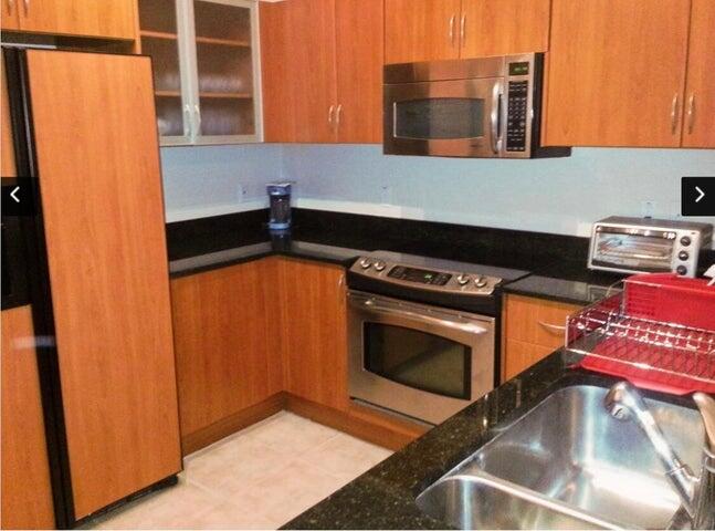 a kitchen with stainless steel appliances granite countertop a stove and a microwave
