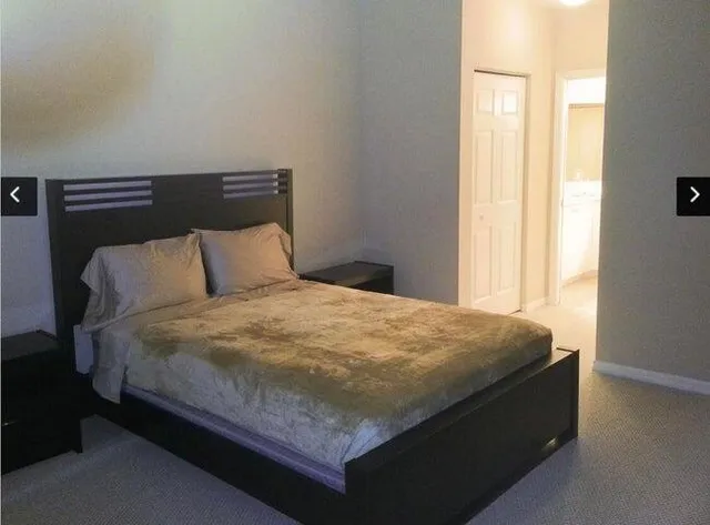 a bed sitting in a bedroom next to a window