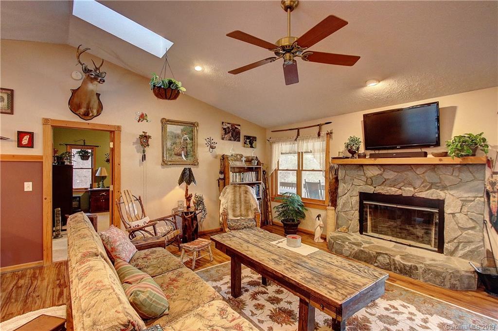 951 Price Town Road Clyde, NC 28721 - Photo 2 of 36 a living room with furniture a flat screen tv and a fireplace
