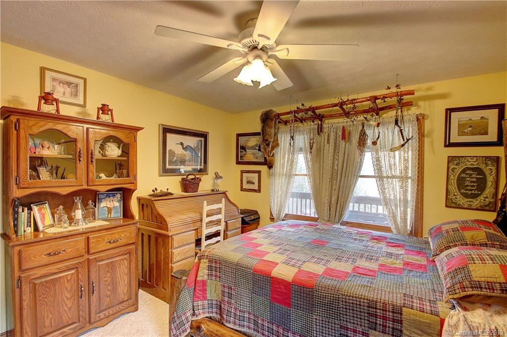 951 Price Town Road Clyde, NC 28721 - Photo 13 of 36 a bed room with a bed and a chair